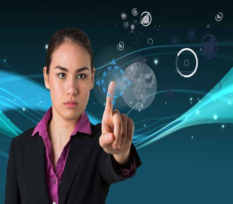 Businesswoman interacting with futuristic technology interface, pointing at digital elements, symbolizing innovation and advanced tech solutions